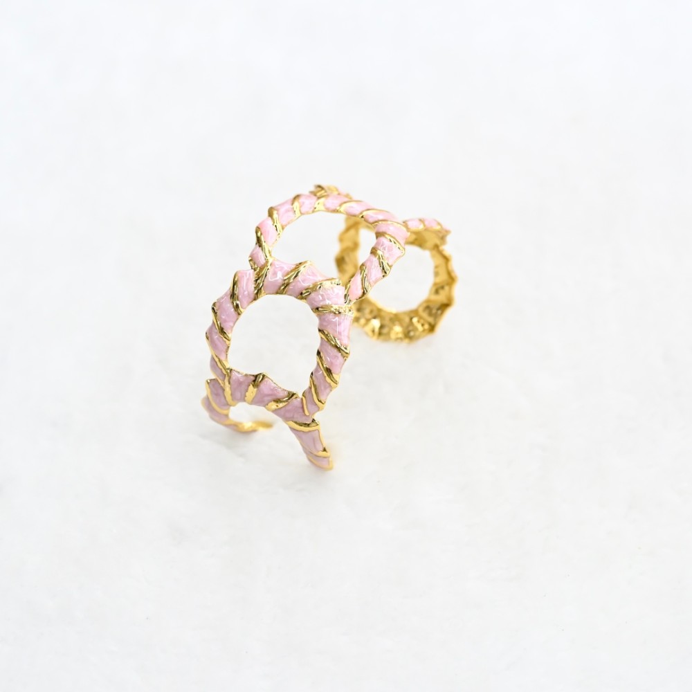 Pink openwork gold cuff bracelet with hollow oval cutout design, textured gold-tone frame and pink enamel-style inlay for wholesale jewelry buyers