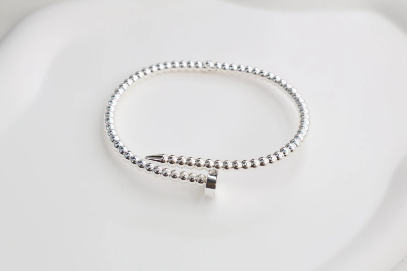 Silver beaded open cuff bracelet with polished bead line design, nail-inspired wrap structure and minimalist metal finish for wholesale jewelry buyers