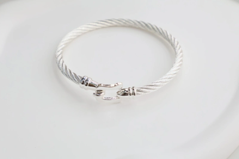 Silver cable open cuff bracelet with twisted wire texture, polished metal clasp detail and minimalist bangle structure for wholesale jewelry buyers