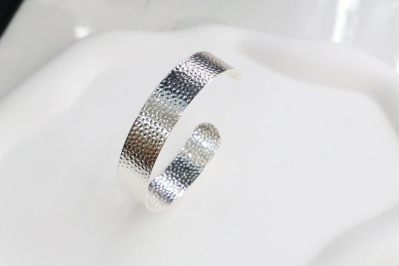 Silver hammered open cuff bracelet with textured metal surface, wide bangle structure and modern statement design for wholesale jewelry buyers