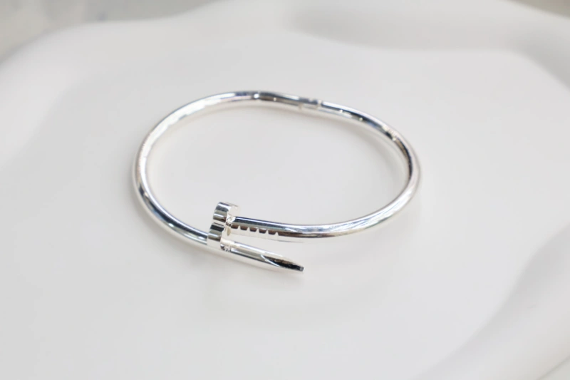 Silver nail open cuff bracelet with polished metal finish, nail-inspired front detail and minimalist bangle structure for wholesale jewelry buyers