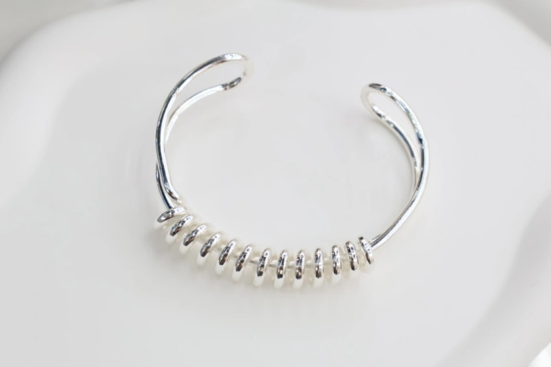 Silver pearl disc open cuff bracelet with polished metal finish, white pearl-like disc accents and minimalist open bangle structure for wholesale jewelry buyers