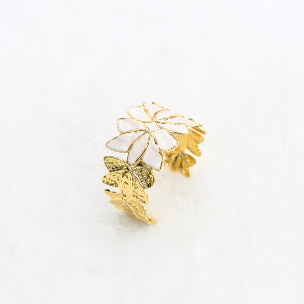 White flower gold leaf cuff bracelet with enamel-style petals, textured gold-tone leaves and open statement design for wholesale jewelry buyers