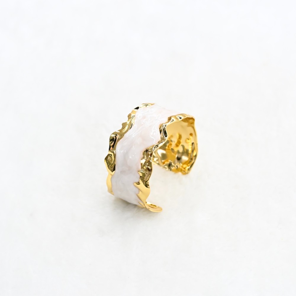 White marble-style gold cuff bracelet with irregular hammered gold-tone edges and open adjustable design for wholesale jewelry buyers