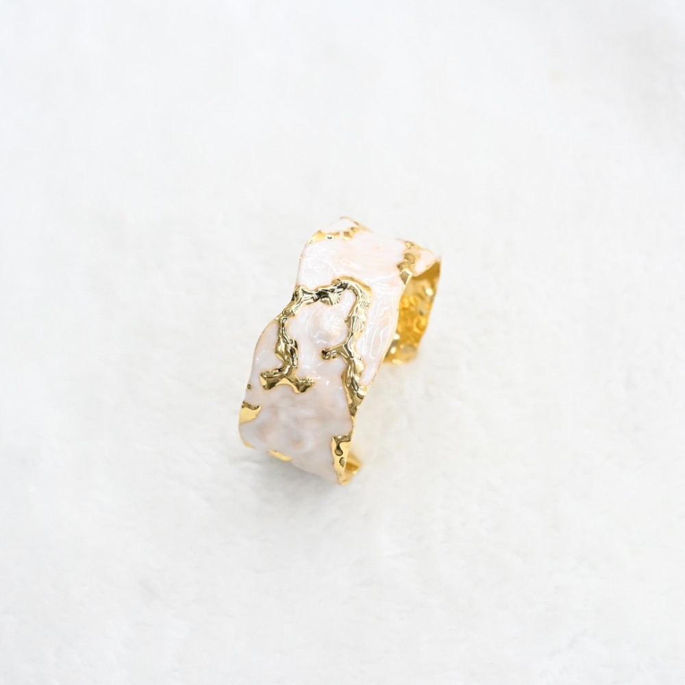 White marble-style irregular gold cuff bracelet with hammered gold-tone cutout details and open adjustable design for wholesale jewelry buyers