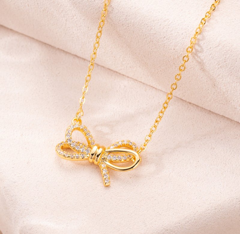 Gold bow pendant necklace with rhinestone bow detail, fine gold-tone chain and feminine gift-ready style for wholesale jewelry buyers