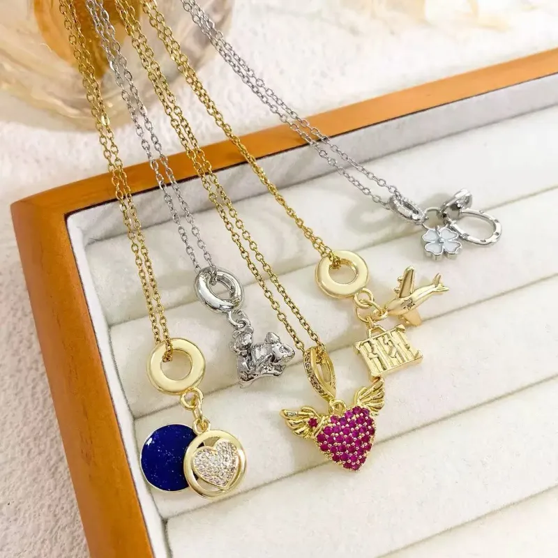 Gold and silver charm pendant necklaces set with heart, wing, airplane, bear, flower and round pendant designs for wholesale jewelry buyers