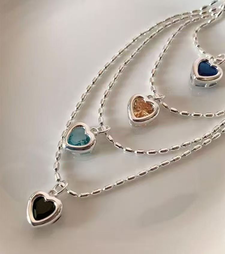 Assorted silver heart pendant necklaces with colorful heart stones and polished silver-tone frames for wholesale jewelry buyers