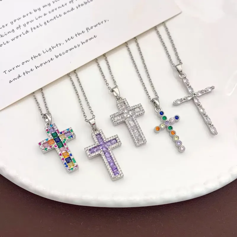 Silver crystal cross pendant necklaces set with multicolor rhinestone, purple stone, clear crystal and delicate cross designs for wholesale jewelry buyers