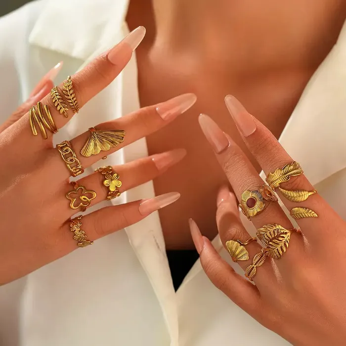 Gold statement rings set with shell, leaf, flower and textured open ring designs shown on hand for wholesale jewelry buyers